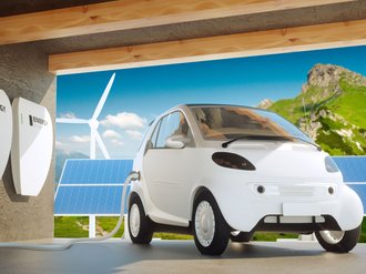 Elektroauto an einer Ladestation vor Solaranlage und Windrad.