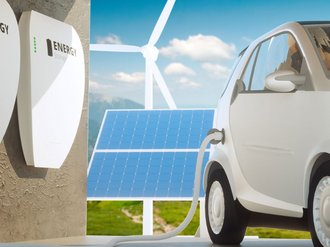 Elektroauto an einer Ladestation vor Solaranlage und Windrad.